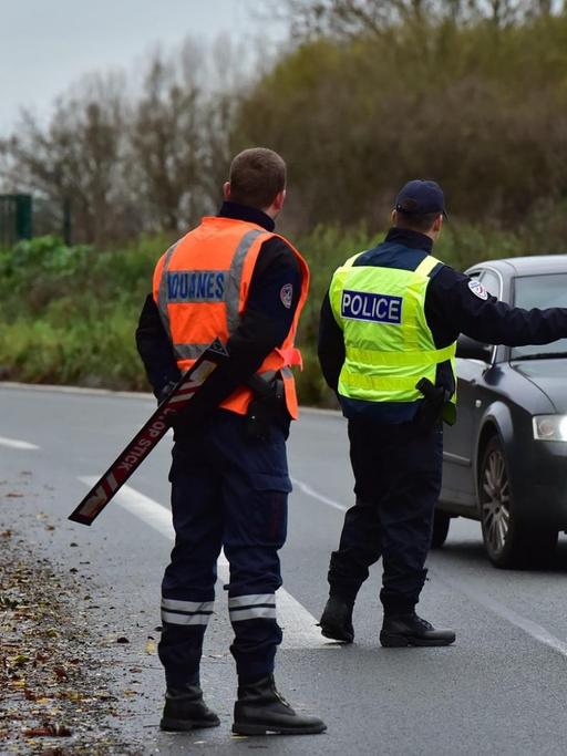 Ein Auto wird an der französisch-belgischen Grenze von zwei Beamten gestoppt.