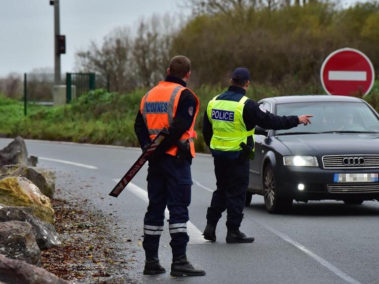 Ein uto wird an der französisch-belgischen Grenze von zwei Beamten gestoppt.