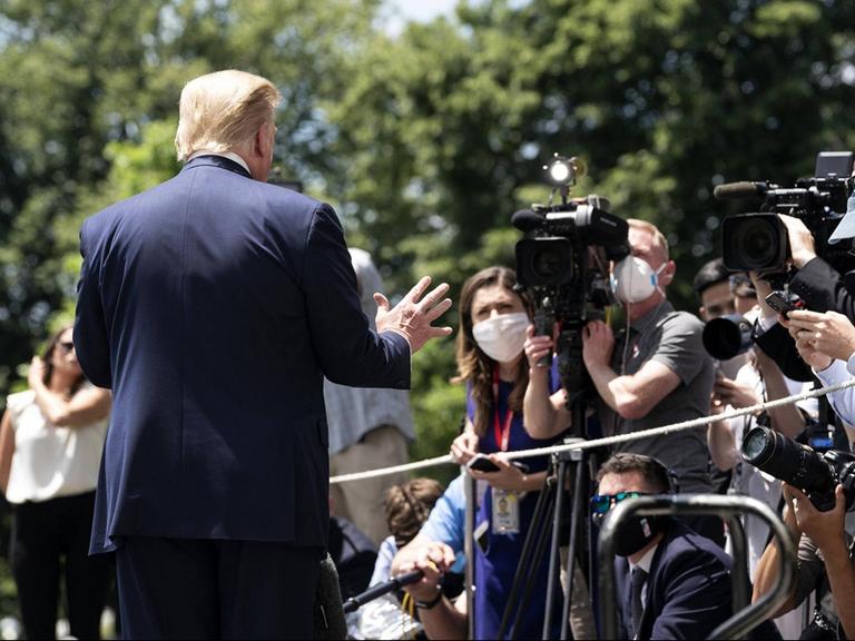 US-Präsident Donald Trump steht mit dem Rücken zum Betrachter vor vielen Journalistinnen und Journalisten