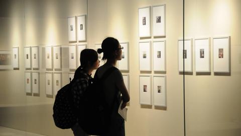 Besuchenden schauen sich Bilder der Berliner Fotografin Sibylle Bergemann in einer Ausstellung in Nanjing in China an.