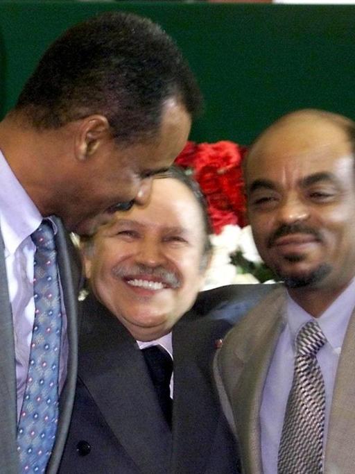 Ein Farbfoto zeigt den algerischen Präsidenten Abdelaziz Bouteflika mit dem Präsidenten Eritreas, Issaias Afewerki links von ihm und Äthiopiens Regierungschef Meles Zenawi rechts im Arm.