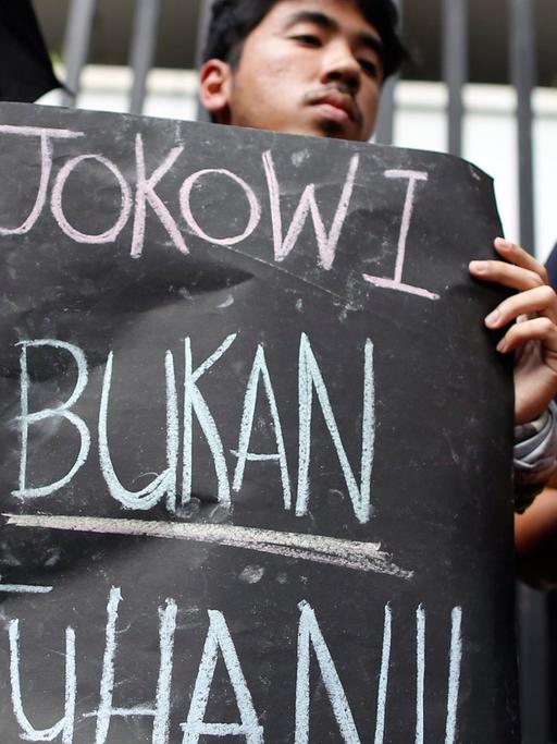Ein Demonstrant gegen die Hinrichtungen hält ein Schild mit der Aufschrift "Jokowi (der indonesische Präsident Joko Widodo) ist nicht Gott".