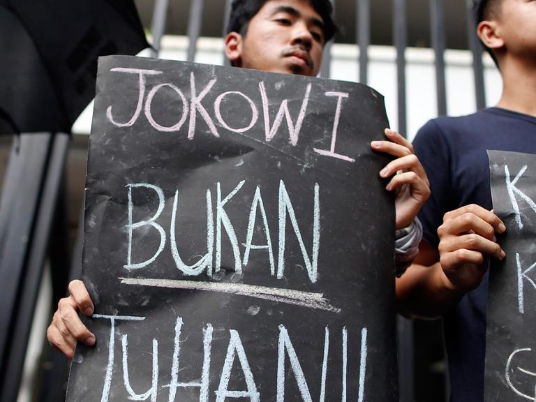 Ein Demonstrant gegen die Hinrichtungen hält ein Schild mit der Aufschrift "Jokowi (der indonesische Präsident Joko Widodo) ist nicht Gott".