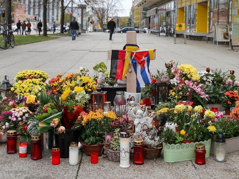 Ein Grabkreuz, Fahnen, Blumen und Kerzen stehen an der Stelle, an der ein 35 Jahre alter Deutscher in der Nacht zum 26. August Opfer einer tödlichen Messerattacke geworden war.