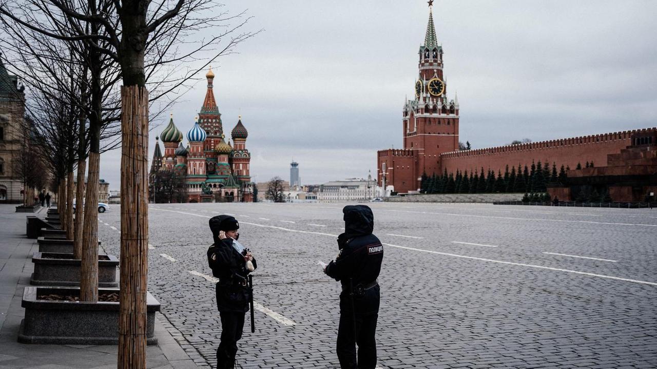 Polizisten stehen während des Lockdowns in Moskau auf leeren Straßen.