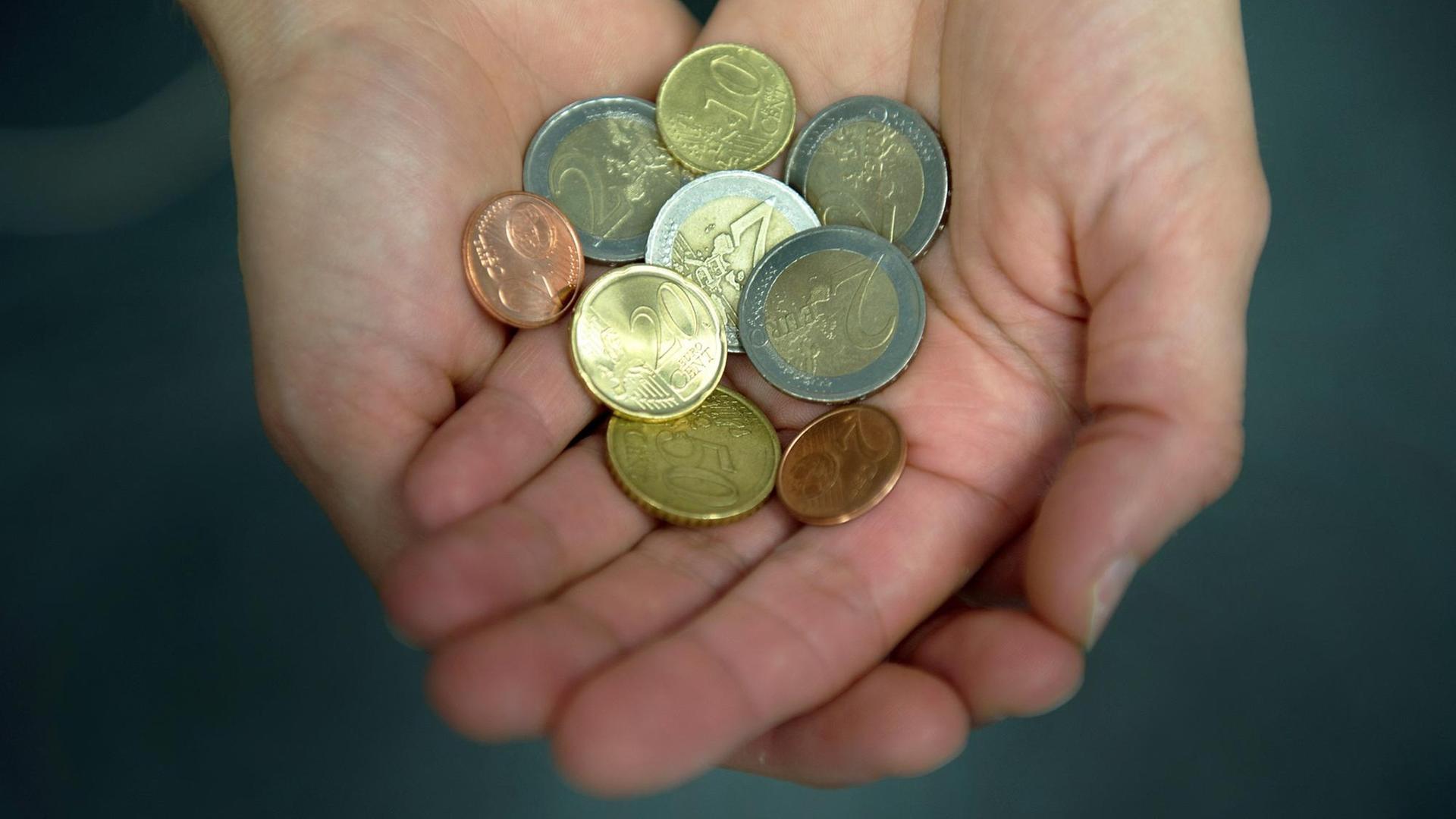 Eine Frau hält 8,84 Euro in Münzen in ihren Händen.