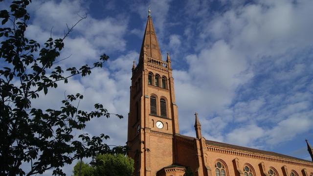 Im Sonnenschein steht das Gebäude der Zwölf-Apostel-Kirche in Berlin an einem Sommertag.