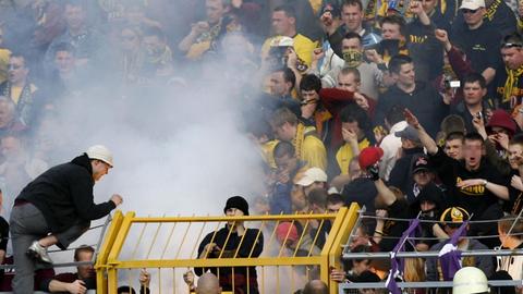 FC Erzgebirge Aue - 1. FC Dynamo Dresden am Sonntag (02.04.2006) im Auer Erzgebirgsstadion. Dresdner Fans zünden während der ersten Halbzeit ein Feuer in ihrem Block, ein Fan mit schwarzem Dynamo-Pullover (r) benutzt den verfassungsfeindlichen "Hitler-Gruß"
