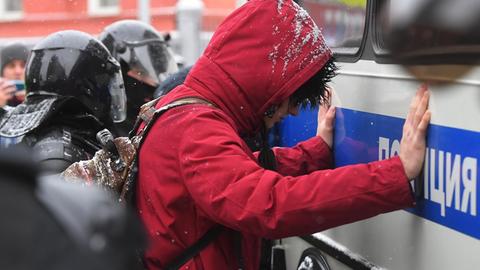Eine Demonstrantin wird während Protesten gegen die Inhaftierung von Kreml-Kritiker Nawalny an ein Polizeiauto in Moskau gedrückt.