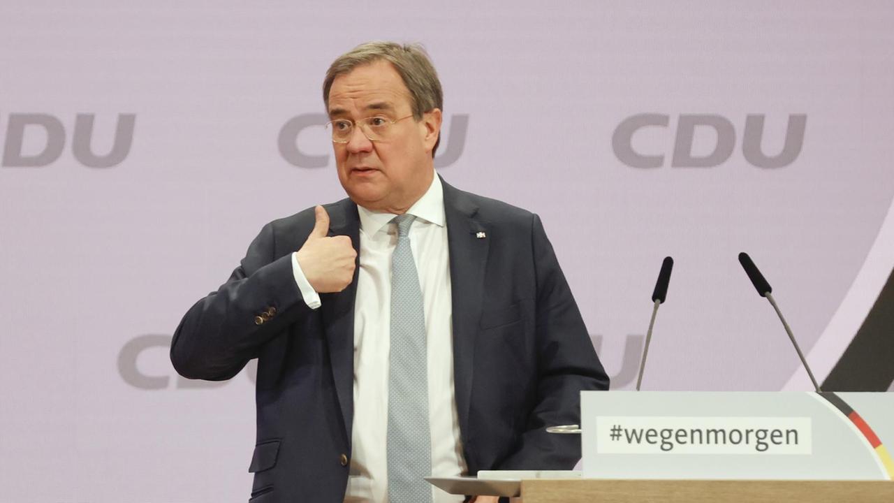 Armin Laschet steht vor dem Rednerpult beim CDU-Parteitag und hebt den Daumen seiner rechten Hand.