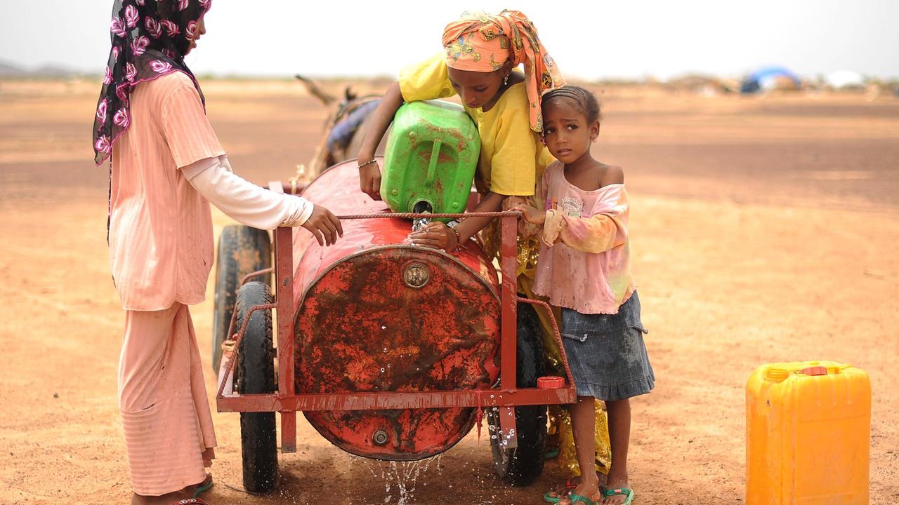 Drei Mädchen aus Mali holen Wasser in einem Flüchtlingscamp in der Nähe von Dori, Burkina Faso.