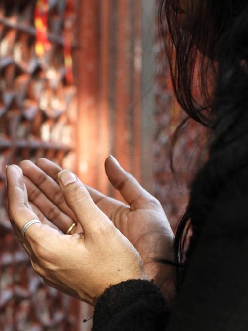 Eine betende Frau in Nizzamuddin Dargah