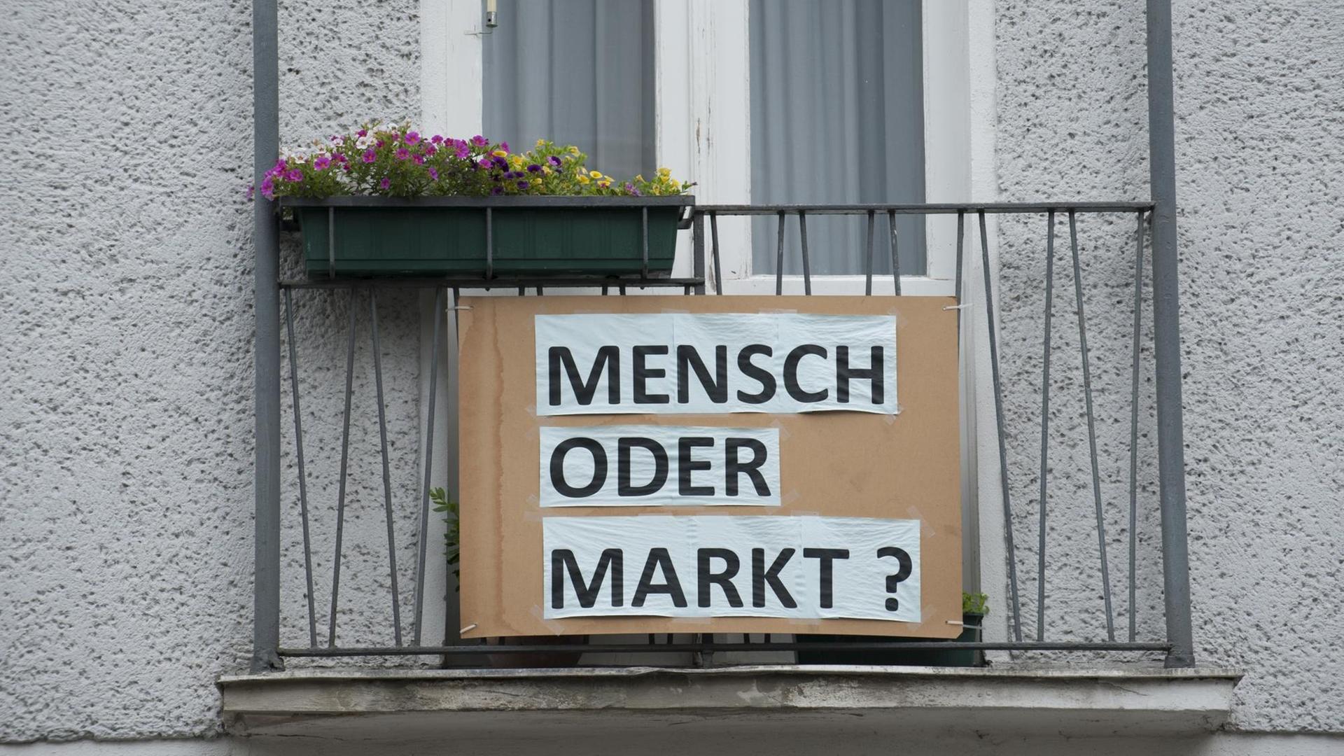 Plakat an einem Berliner Haus: "Markt oder Mensch?"