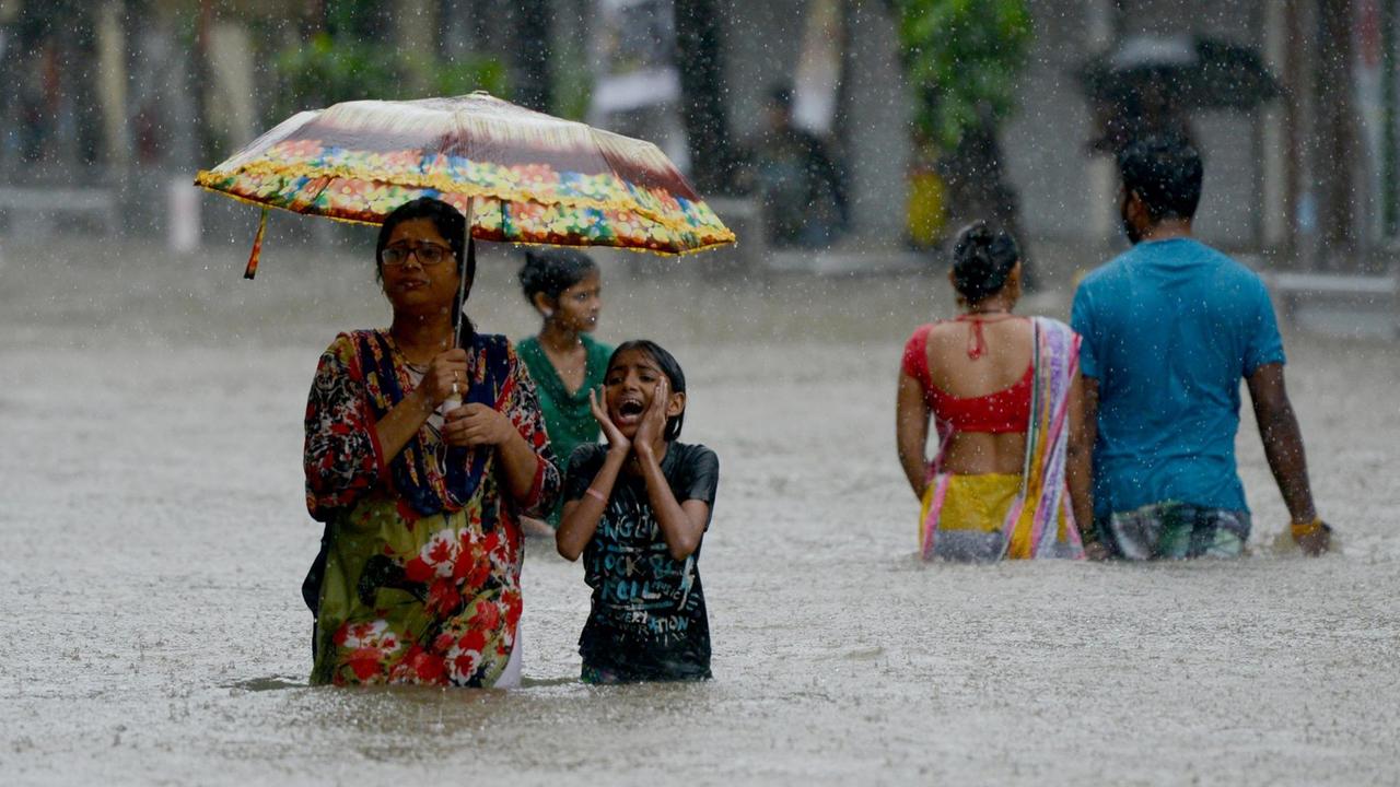 In Mumbai waten Menschen am 29. August 2017 über eine überflutete Straße.