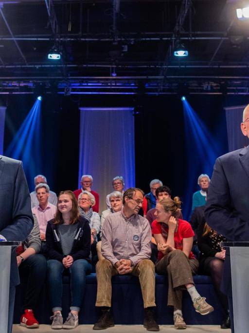 Das Bild zeigt Manfred Weber und Frans Timmermans, Sie stehen während einer Fernsehdebatte hinter Pulten.
