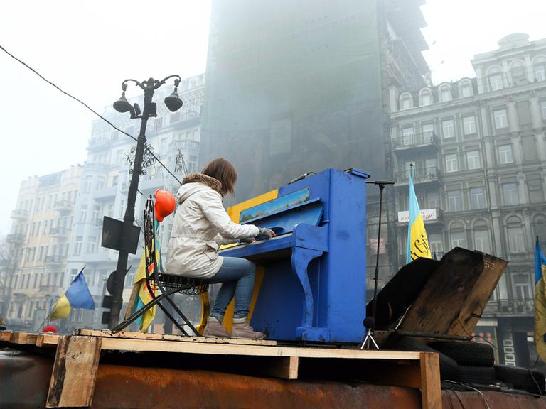 Eine Frau spielt Klavier bei den Protesten auf dem Majdan in Kiew am 10. Februar 2014.