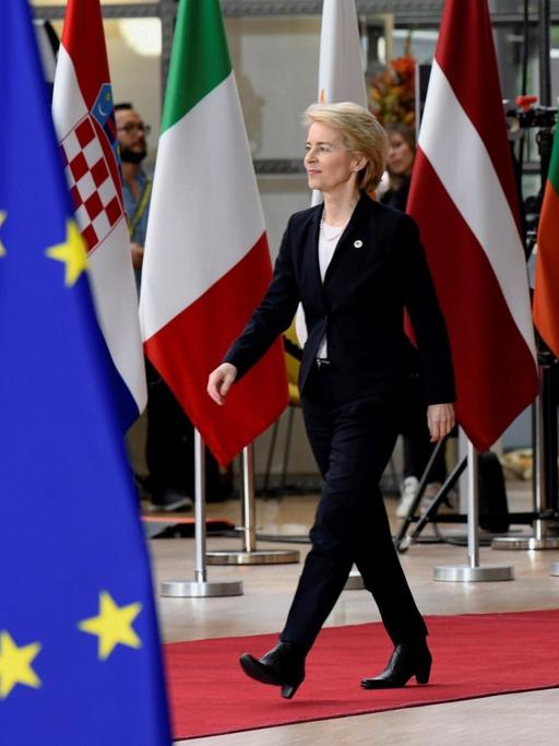Die CDU-Politikerin Ursula von der Leyen läuft an zahlreichen Flaggen im EU-Hauptquartier in Brüssel entlang.