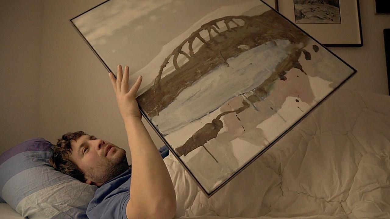 André Simonow liegt in seinem Bett. Szene aus „Scheitern und das schöne Leben”.