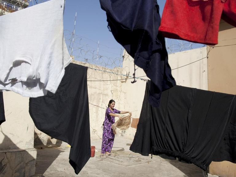 Blick in den Innenhof der Haftanstalt für Frauen in Mazar-E-Sharif in Afghanistan, in dem eine Wäscheleine hängt, im Hintergrund ist eine Frau zu sehen, aufgenommen im Oktober 2010
