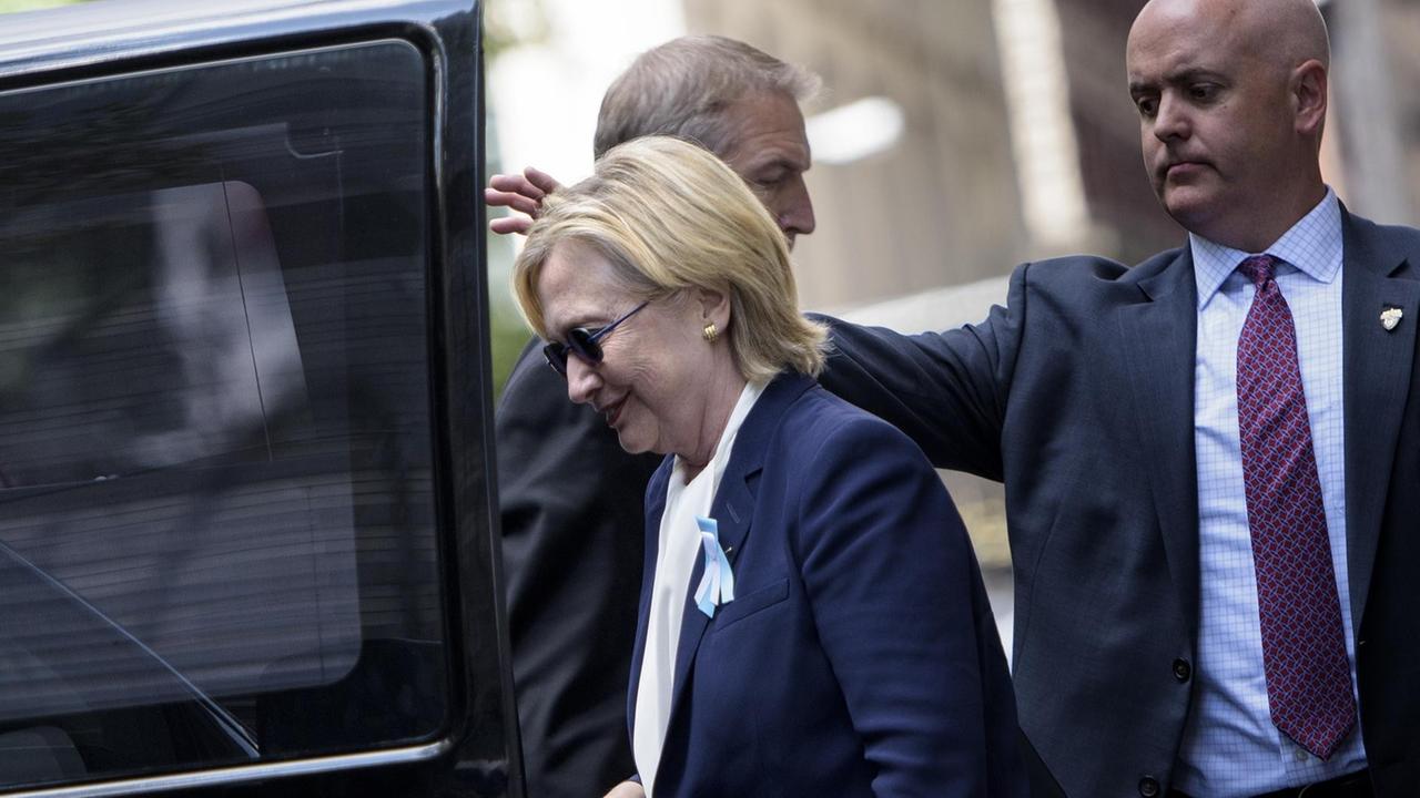 Nach der Gedenkveranstaltung für die Opfer der Anschläge vom 11. September wird Hillary Clinton von Sicherheitsbeamten zu ihrer Tochter gebracht.
