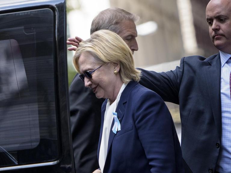 Nach der Gedenkveranstaltung für die Opfer der Anschläge vom 11. September wird Hillary Clinton von Sicherheitsbeamten zu ihrer Tochter gebracht.