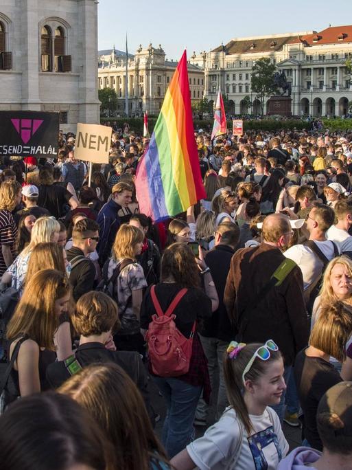 Viele Menschen protestieren in Budapest gegen ein Gesetz zu Homosexualität. In der Mitte ist eine Regenbogenfahne zu erkennen.