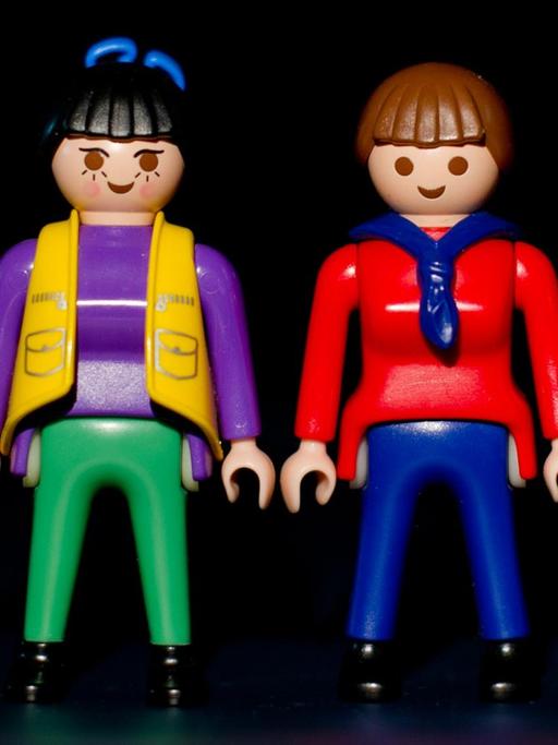 Zwei Playmobil-Frauen stehen zwischen zwei Playmobil-Männern.