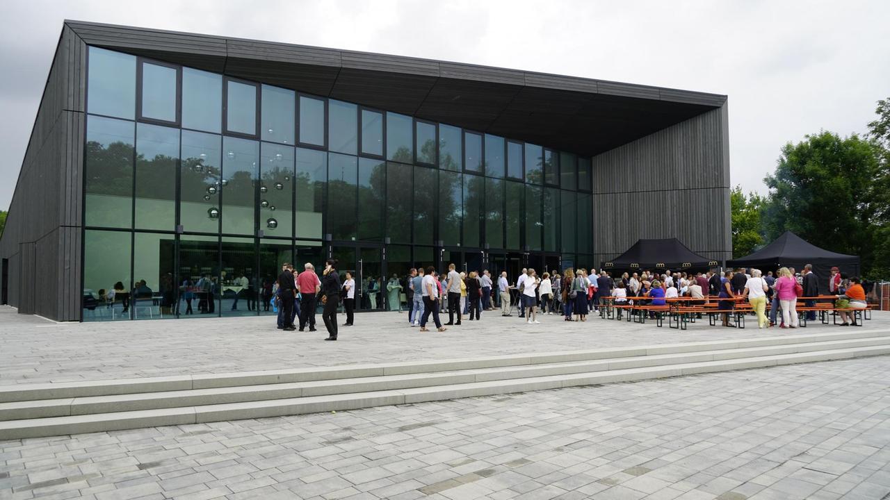 Das bild zeigt Besucher vor der Tauberphilharmonie