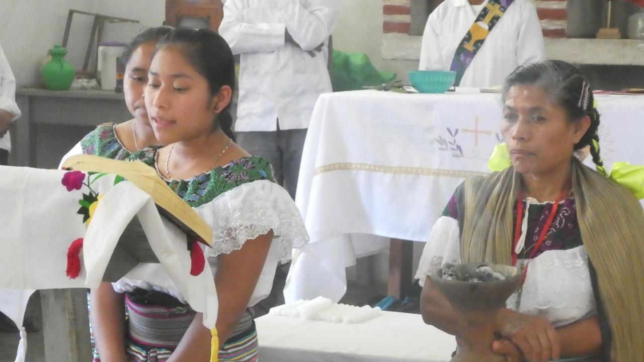 Eine junge Frau verliest im Gottesdienst die Namen der Verstorbenen des Dorfes "Centro Triaquil".