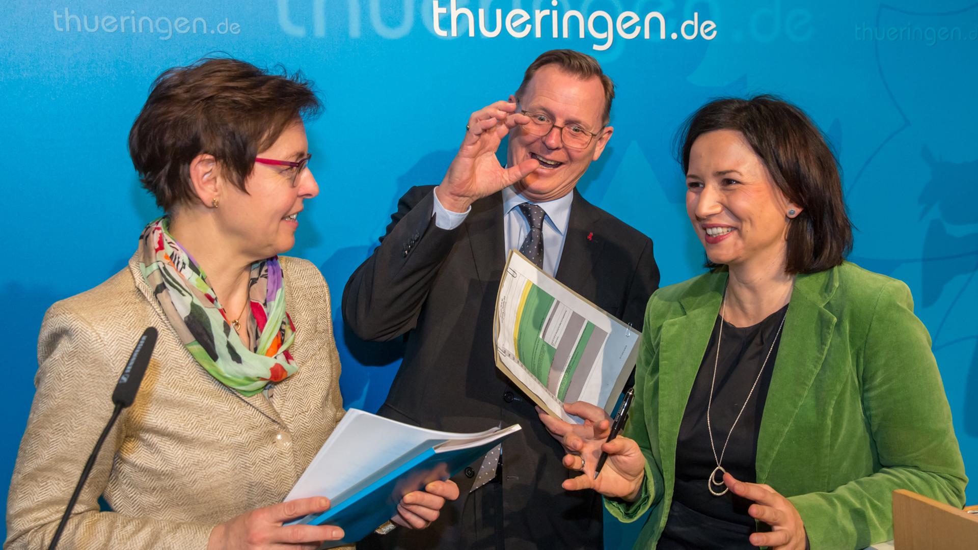 Thüringens Ministerpräsident Bodo Ramelow (Die Linke) scherzt mit der Vize-Ministerpräsidentin Heike Taubert (l., SPD) und der zweiten Vertreterin des Ministerpräsidenten Anja Siegesmund (Bündnis 90/Die Grünen). Thüringens Ministerpräsident Bodo Ramelow (Die Linke) scherzt mit der Vize-Ministerpräsidentin Heike Taubert (l., SPD) und der zweiten Vertreterin des Ministerpräsidenten Anja Siegesmund (Bündnis 90/Die Grünen).