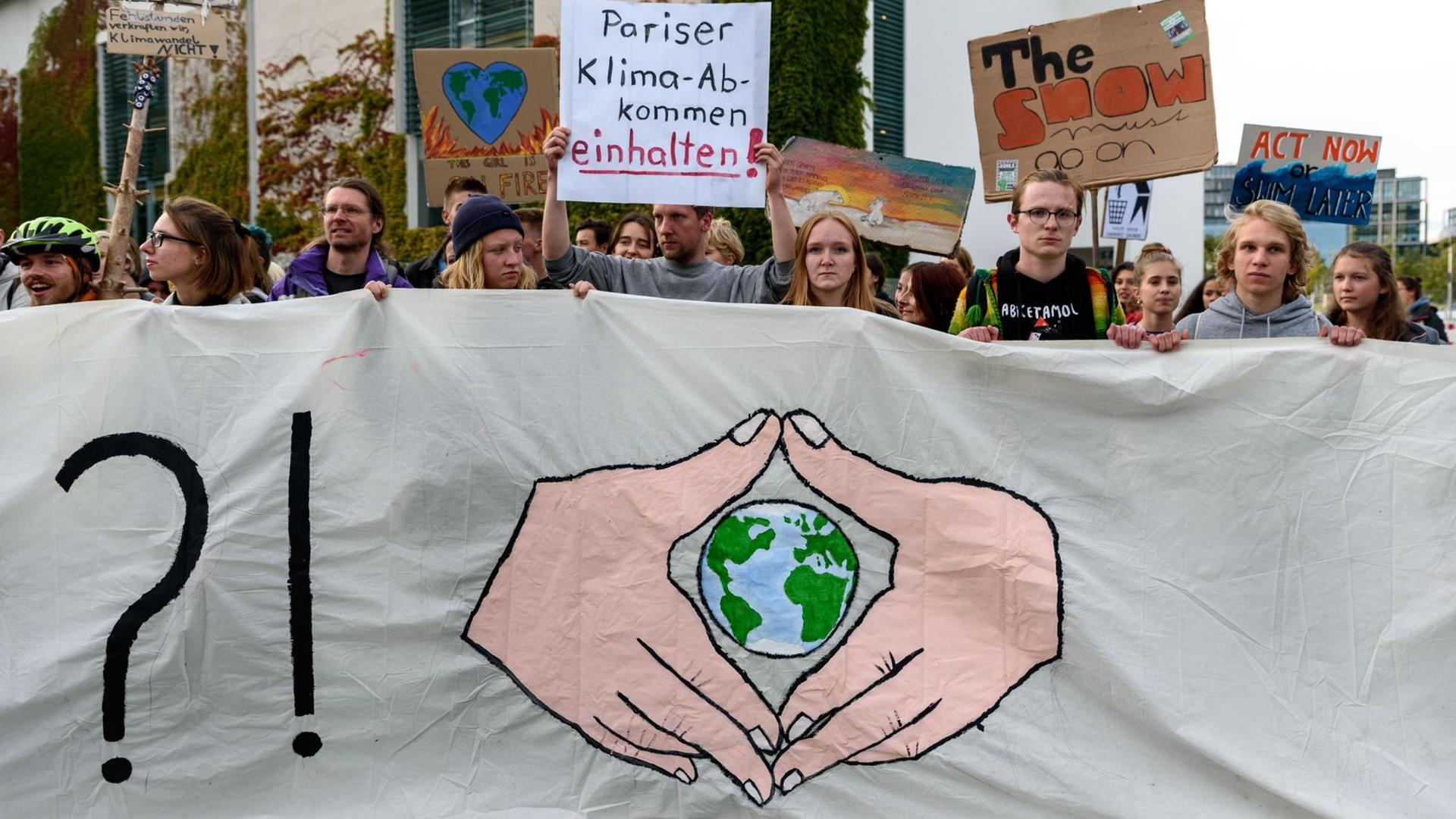 Menschen mit Plakaten zum Klimaprotest