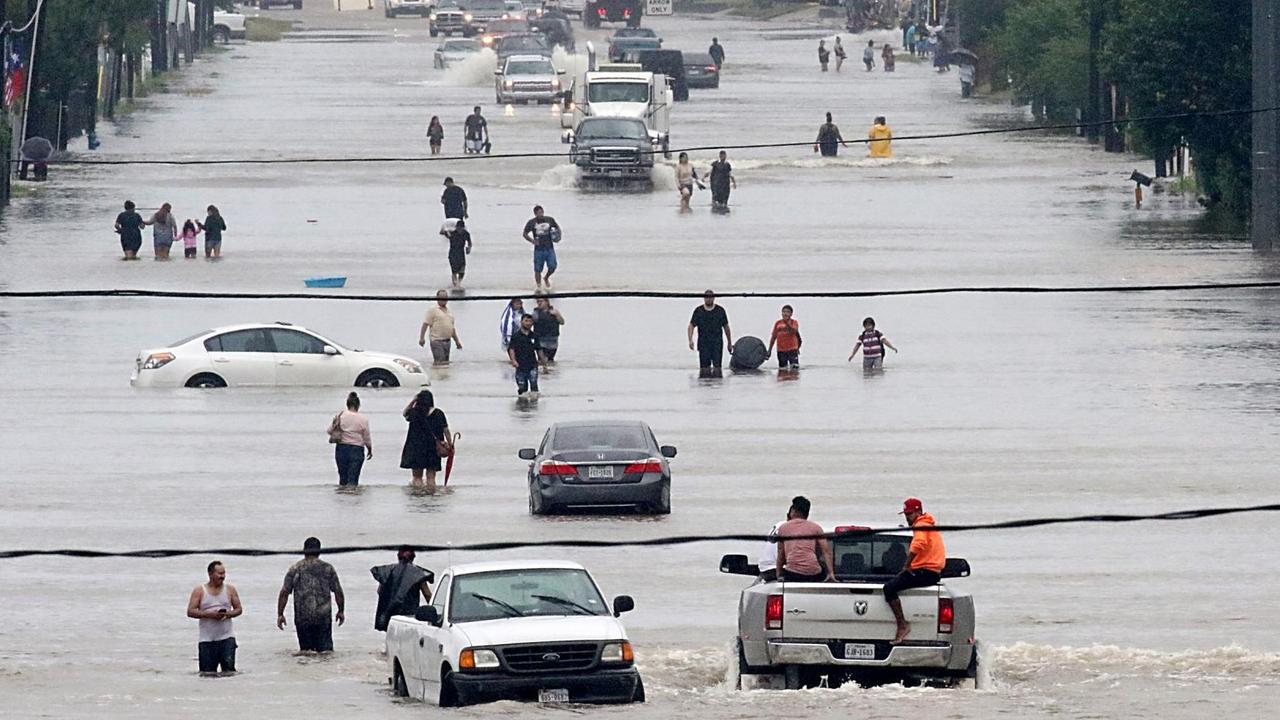 Passanten und Autos auf einer überfluteten Straße in Houston im US-Bundesstaat Texas am 27. August 2017.