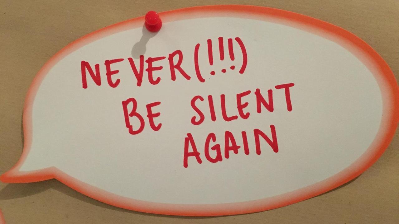 Karte auf einer Pinnwand bei der Voice-Konferenz: "Never be silent again" - Nie wieder still sein.