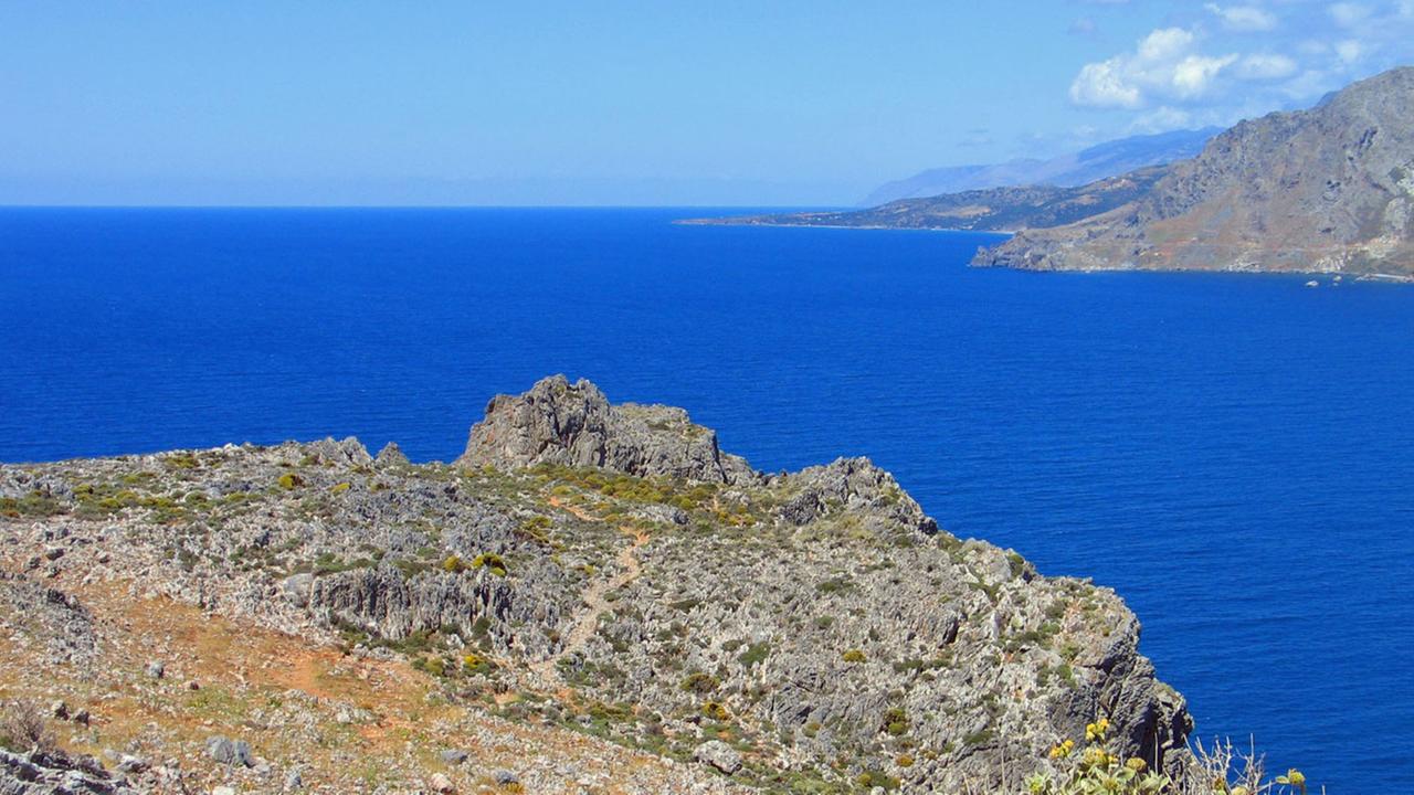 Steil aufragende Berge begrenzen die Bucht von Plakias an der Südküste Kretas. Auf ihrem kargen, felsigen Boden wachsen die typischen Pflanzen der Macchie und der Garigue.