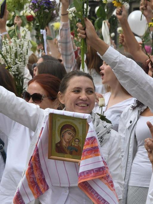 Frauen nehmen mit Blumen an den Demonstrationen gegen den Wahlbetrug bei den Präsidentschaftswahlen teil.