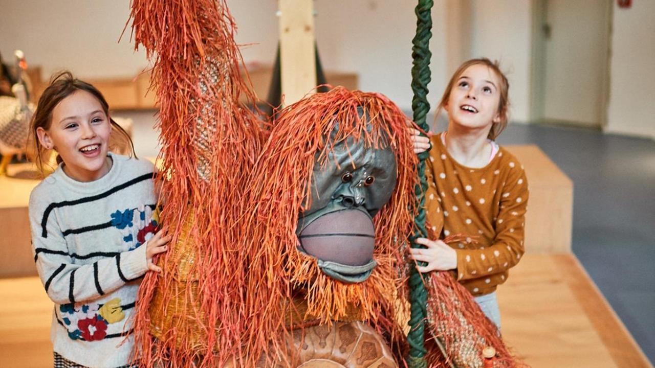 Zwei Kinder und ein Spiel-Orang-Utan in der Kinderwelt des Jüdischen Museums Berlin.