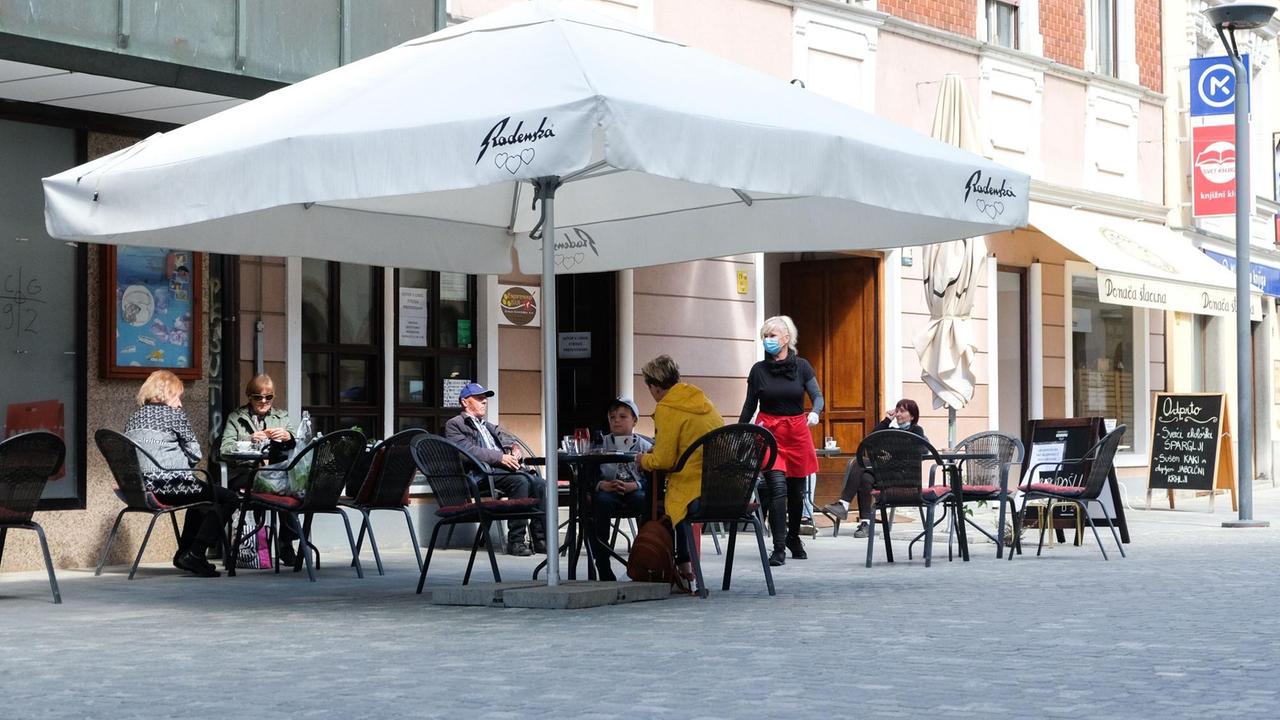 Gäste sitzen im Außenbereich eines Restaurants. 