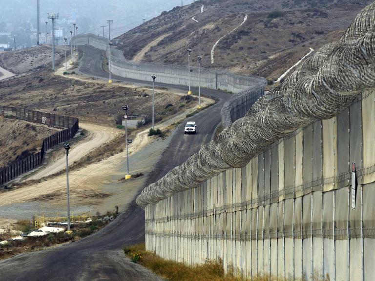 US-Grenzfahnder fahren in einem Auto an Mauern und Befestigungen an der Grenze zu Mexiko entlang, bei Otay Mesa, Kalifornien, USA, am 14. Oktober 2010.