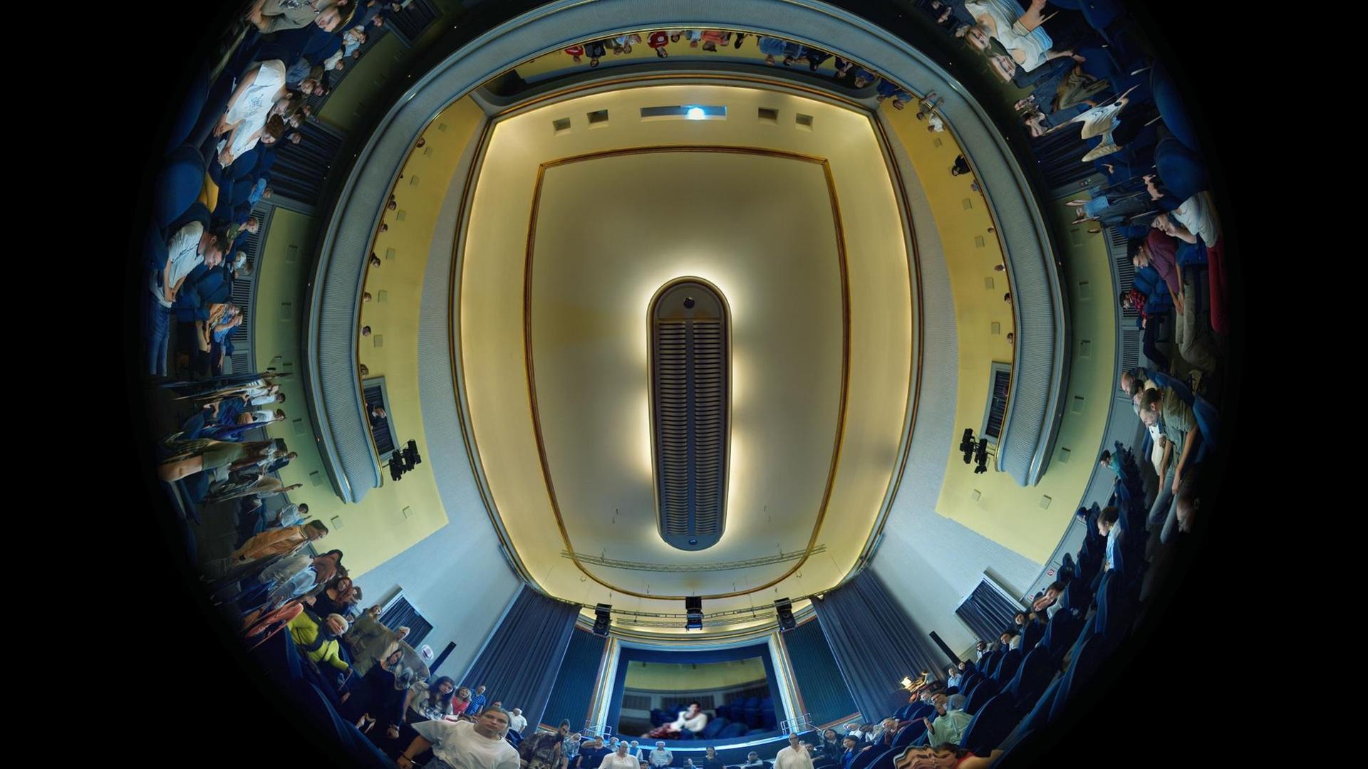 Die Aufnahme von Martin Reinharts und Virgil Widrichs "tx-reverse 360°" ziegt einen Rundumblick eines Kinosaals mit Zuschauern aus der Bodenperspektive