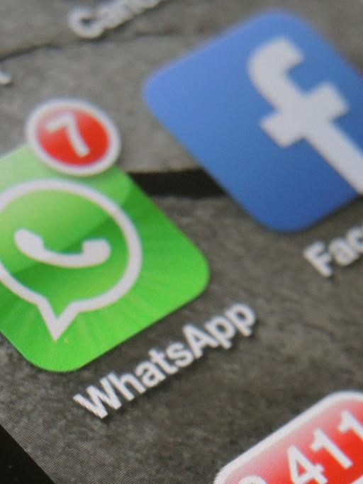 Auf einem Smartphone werden nebeneinander die beiden Apps von WhatsApp und Facebook angezeigt.