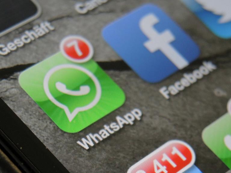 Auf einem Smartphone werden nebeneinander die beiden Apps von WhatsApp und Facebook angezeigt.