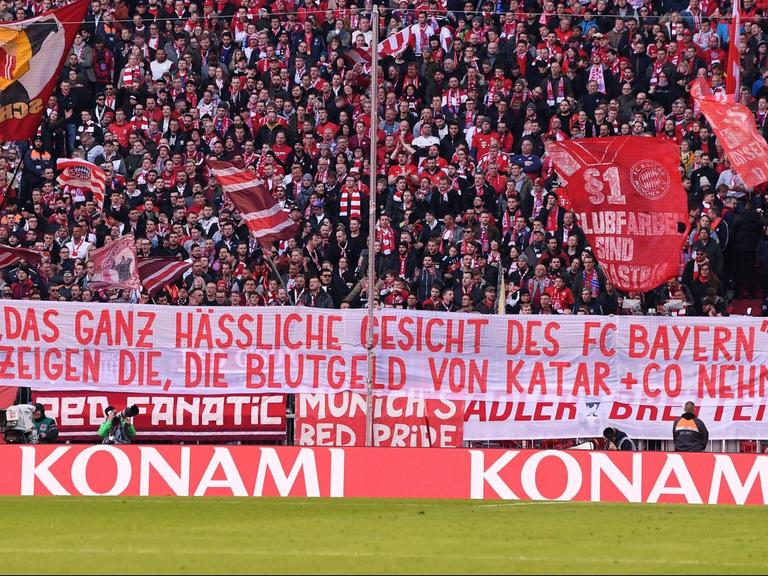 Fans hissen bei einem Fußballspiel ein Banner, auf dem steht: "Das ganz hässliche Gesicht des FC Bayern München zeigen die, die Blutgeld von Katar und Co nehmen"