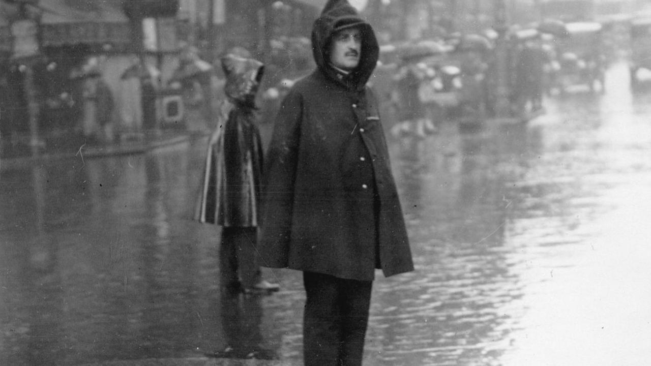 Ein französischer Händler erträgt stoisch den Regen (um 1930).