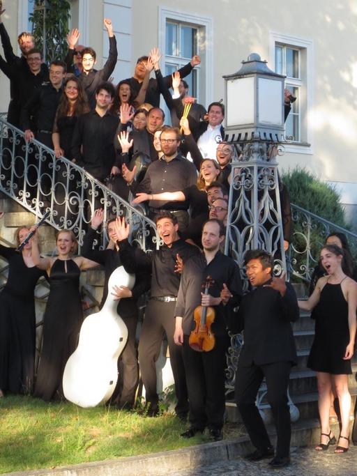 Die Teilnehmer des Krzyzowa Music Festivals stehen mit ihren Instrumenten auf der Treppe des Gutshauses der Familie Moltke in Kreisau