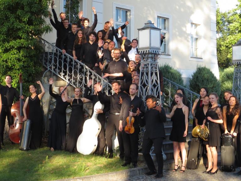 Die Teilnehmer des Krzyzowa Music Festivals stehen mit ihren Instrumenten auf der Treppe des Gutshauses der Familie Moltke in Kreisau