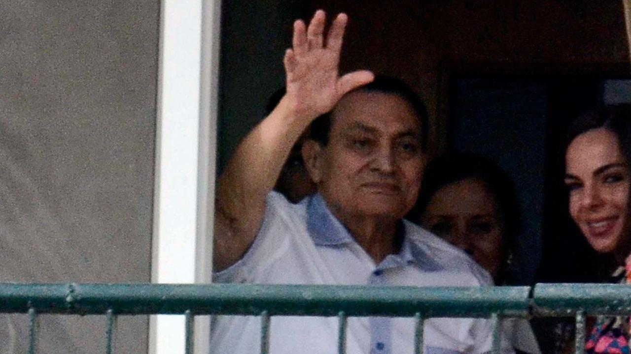 Der frühere ägyptische Präsident Hosni Mubarak winkt von seinem Zimmer hinter einem Balkon aus seinen Anhängern zu.