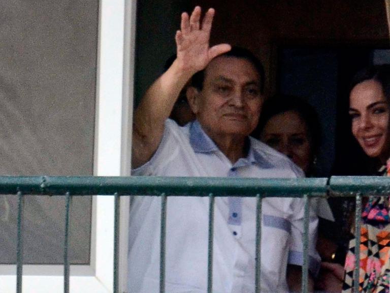 Der frühere ägyptische Präsident Hosni Mubarak winkt von seinem Zimmer hinter einem Balkon aus seinen Anhängern zu.