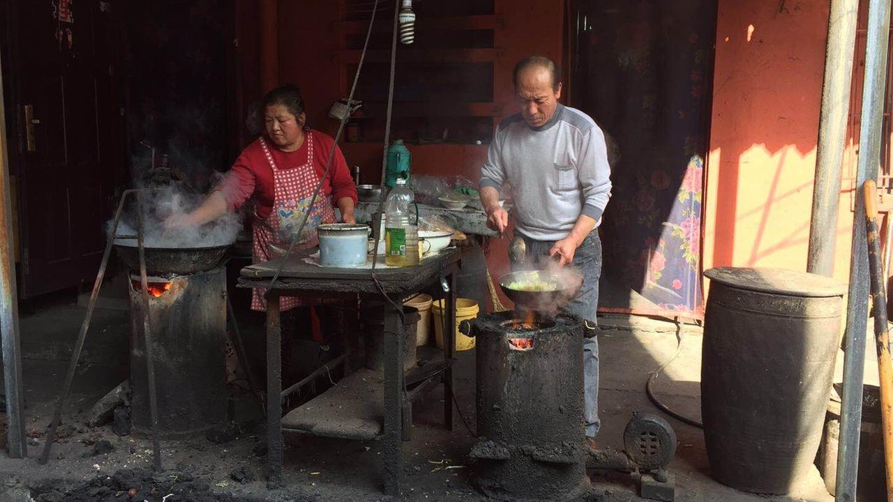Ein Nudelladen in Yangquan für die Kohlearbeiter. Eine Frau und ein Mann kochen improvisiert mit 2 Töpfen.