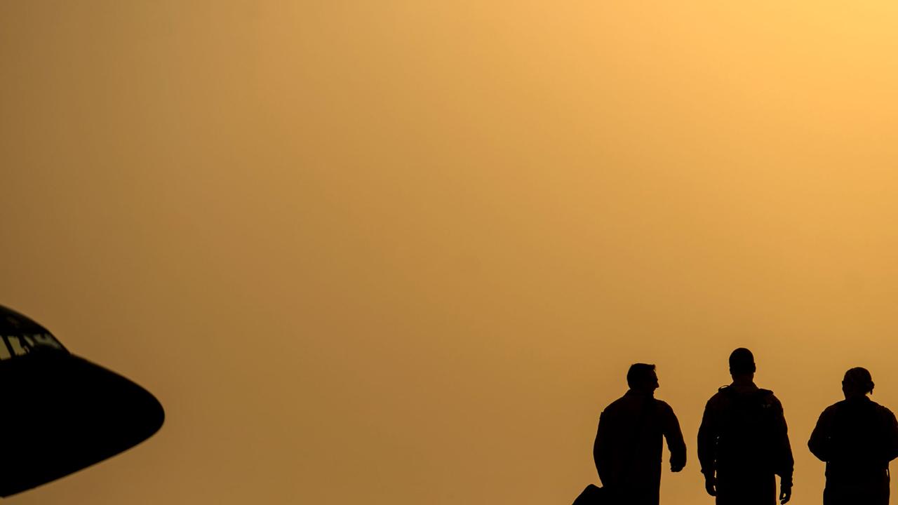 Drei Mitglieder Männer laufen sind auf dem Weg zu einem Betankungsflugzeug, um US-Kampfjets in der Luft mit neuem Treibstoff zu versorgen.