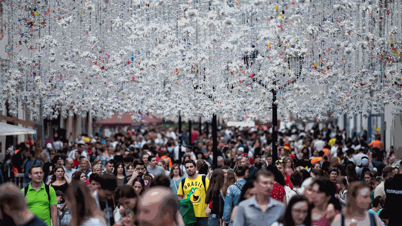 Ausländische Fans und Russen gehen über die Straße "Nikolskaja" in Moskau, die mit zahlreichen Lichterketten dekoriert ist.